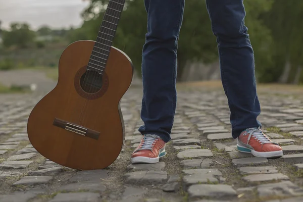 Adamın bacakları Jeans ile gitar boş köy yolunda — Stok fotoğraf