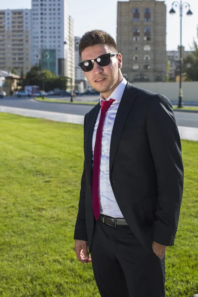 Jovem empresário em um terno e óculos e gravata vermelha . — Fotografia de Stock