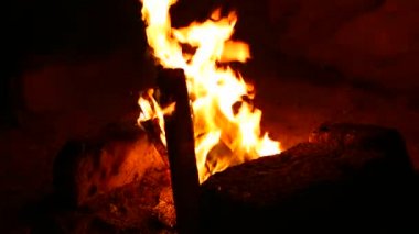 Kamp ateşi, Azerbaycan'ın güzel Hazar denizi plajı boyunca gün batımında parlak bir şekilde yanar. Yanan Ateş