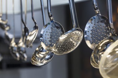 Bej renkli arka plan üzerinde asılı siyah modern mutfak malzemesi kümesi. mutfak kaşık. pişirme araçları. metal mutfak elements.kitchen Kepçe.