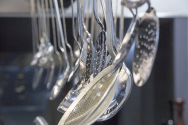 Bej renkli arka plan üzerinde asılı siyah modern mutfak malzemesi kümesi. mutfak kaşık. pişirme araçları. metal mutfak elements.kitchen Kepçe.