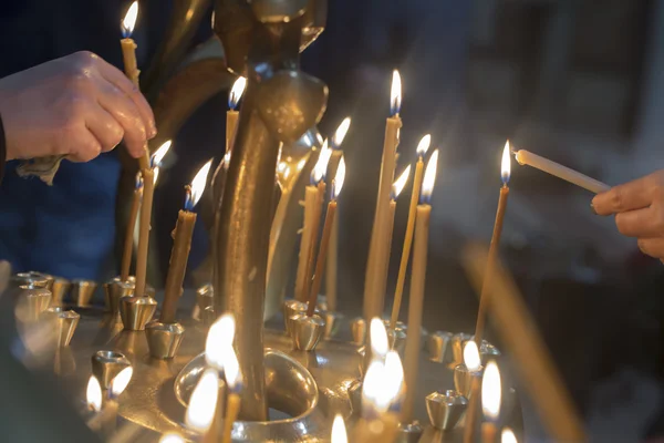 The candles in Georgian Church. Long lighted candles group on black background. — Stock Photo, Image