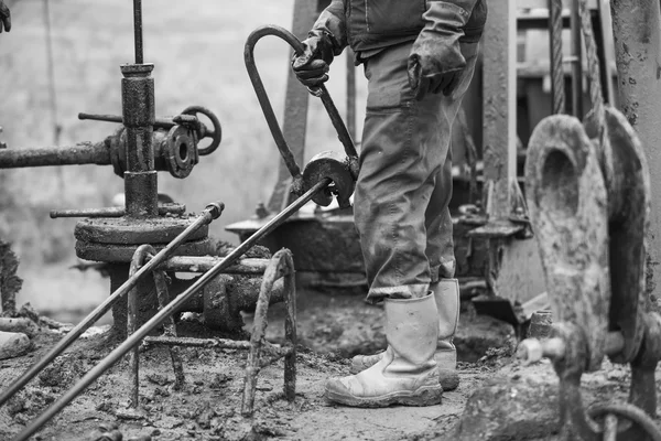 Olie werknemers controleren oliepomp. Roustabouts vuile en gevaarlijke werk op een olie goed onderhoud tuig. — Stockfoto