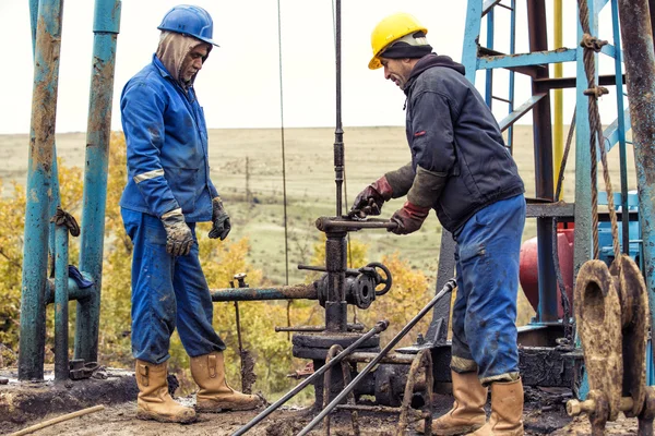 Pracowników oleju sprawdzanie pompy oleju. Roustabouts w naftowy obsługi platformy pracy brudny i niebezpieczne. 2015 listopadzie Shabran, Azerbejdżan — Zdjęcie stockowe