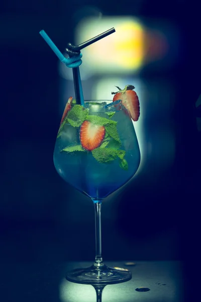 Alcohol coctail drink on the table in restaurant. Fresh drink coctails, green mint and lime on a color background blur bokeh. Fruit coctail. — Stock Photo, Image