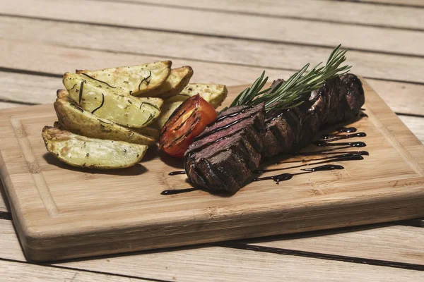 Deliziosa bistecca di manzo sul tavolo di legno, primo piano. Bistecche di vitello alla griglia con verdure sul tagliere . — Foto Stock