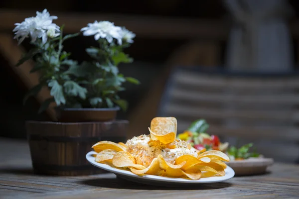 Salat und Pommes zum Mittagessen. Guacamole mit Maissplittern auf dunklem Holz. die Tonung. Selektiver Fokus. — Stockfoto