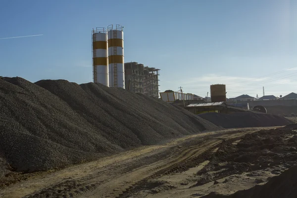 Quarry crusher plant in sand and gravel production. Cement production factory on mining quarry. Conveyor belt of heavy machinery loads stones and gravel. Construction works, machinery factory