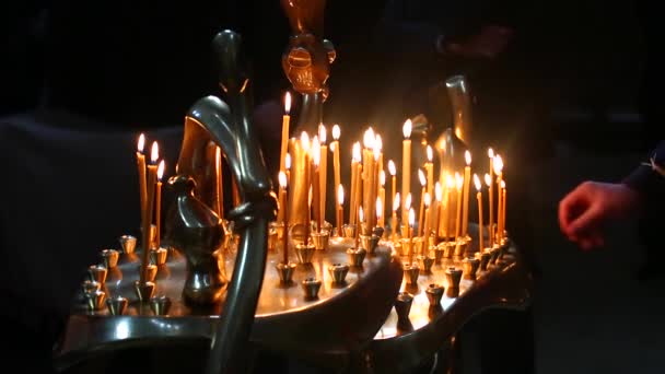 Les bougies dans l'église géorgienne. Long groupe de bougies allumées sur fond noir . — Video