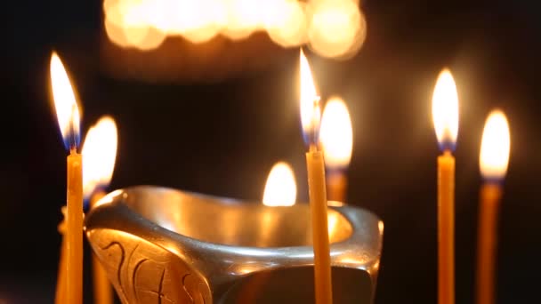 Les bougies dans l'église géorgienne. Long groupe de bougies allumées sur fond noir . — Video