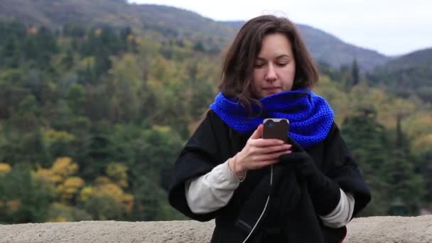 Νεαρή γυναίκα λαμβάνοντας μια φωτογραφία με το τηλέφωνο. Νεαρή γυναίκα τουριστικά λήψη φωτογραφιών για την όμορφη θέα της Ευρωπαϊκή πόλη με κινητό έξυπνο τηλέφωνο φωτογραφικών μηχανών. — Αρχείο Βίντεο