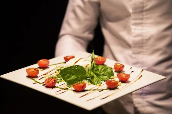 Cuenco blanco de ensalada mediterránea fresca y saludable con queso mozzarella, tomates y hojas de albahaca. Caprese: tomate cherry, bolas de mozzarella y hojas de albahaca . —  Fotos de Stock