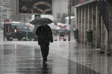 Bükreş, Romanya - 30 Kasım 2020: Koronavirüs salgını sırasında koruyucu maskeler takan insanlar karda yürüyor.