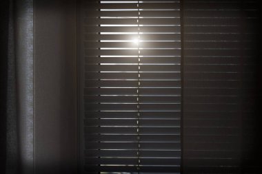 Yatay beyaz panjurlar güneş ışığını engeller.