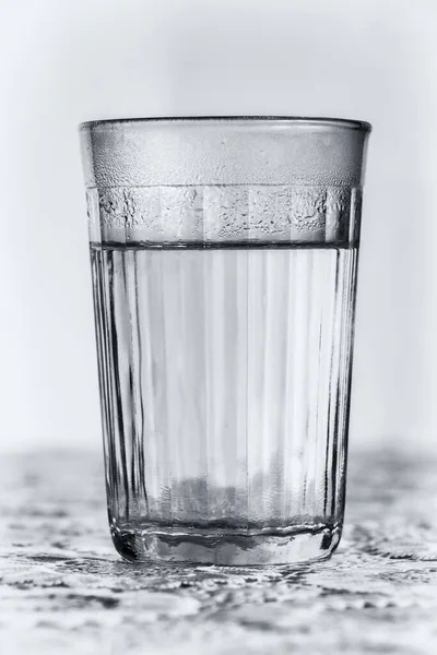 A faceted glass with clean boiled water close-up.