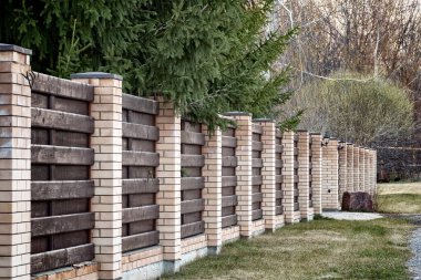 Tuğla ve tahtadan yapılmış özel bir evin çevresindeki çit..