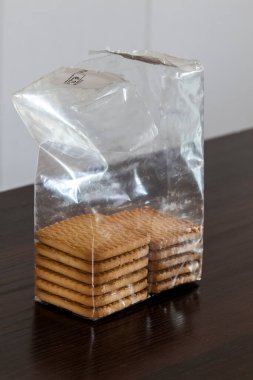 Masanın üzerinde yarı boş bir polietilen kurabiye paketi var..