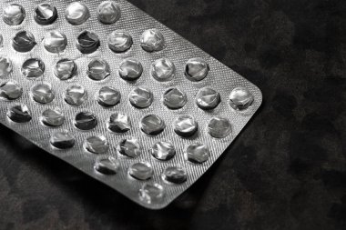 Masanın üzerindeki haplardan gelen buruşuk gümüş ambalajlar..