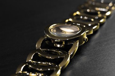 Bileziği olan altın kol saati.