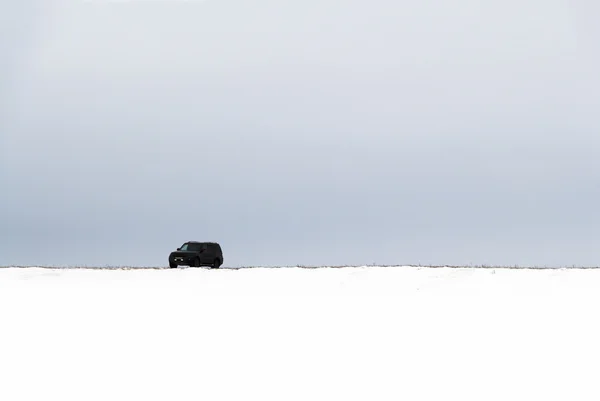 Автомобиль в заснеженном поле — стоковое фото