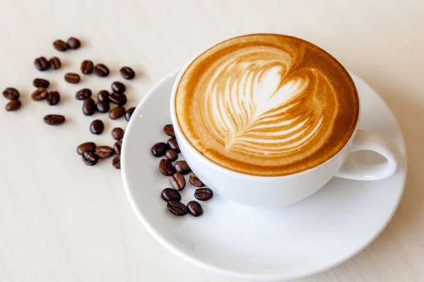 Café caliente con leche y granos de café — Foto de Stock