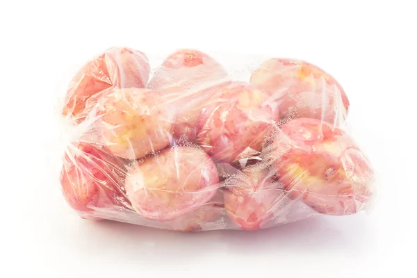 Nové červené brambory v plastovém sáčku — Stock fotografie