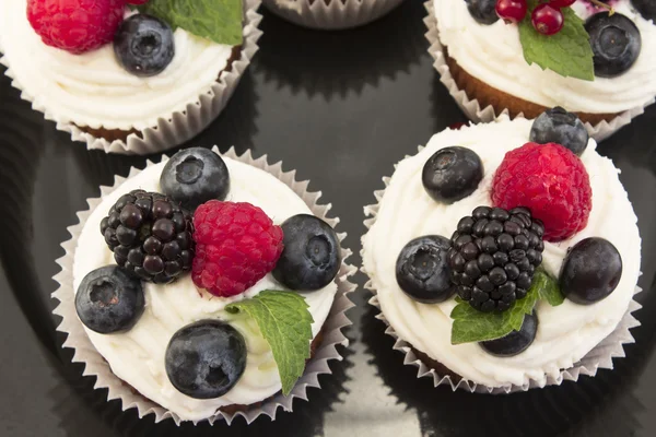 Cupcakes élégants aux baies sur la plaque noire — Photo