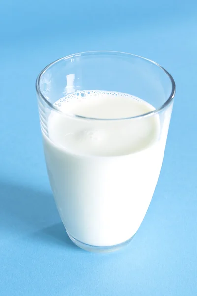 Pohár friss tejért a kék háttér — Stock Fotó