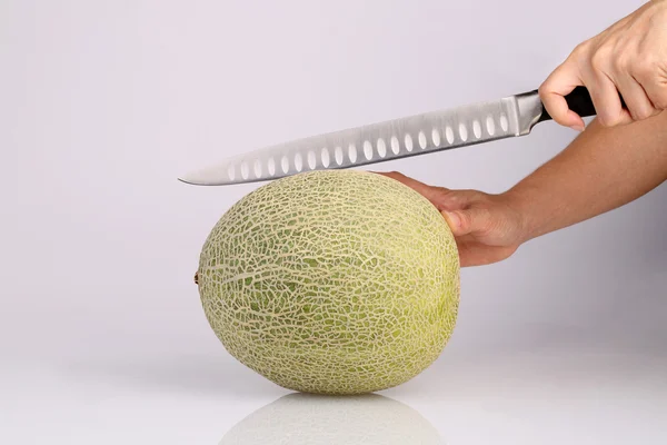 Bio-Melonenfrucht Cantaloupe mit Küchenmesser in der Hand isolat — Stockfoto