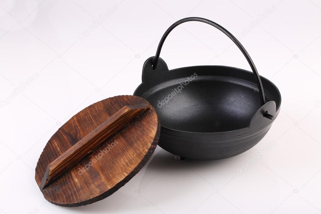 Black iron pot with wooden lid  isolated on white background