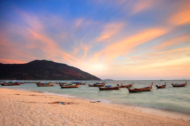 Beautiful Sunset and local fishing boats on seaside at Lipe isla