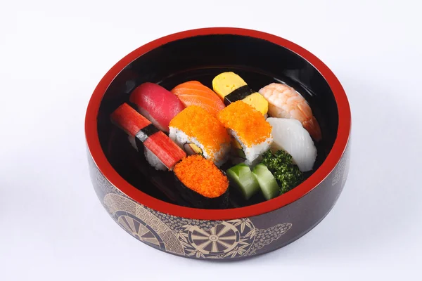 Mixed sushi in wooden bowl isolated on white background