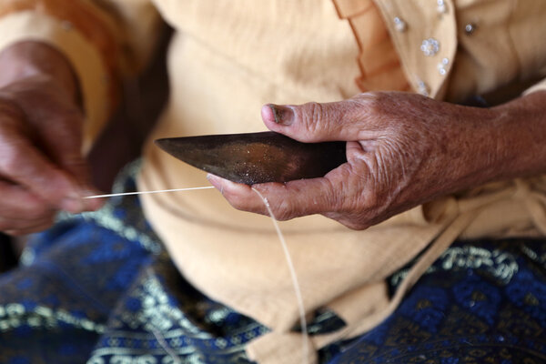 Unidentified old women chamfer thread for weaving thai fabric, C