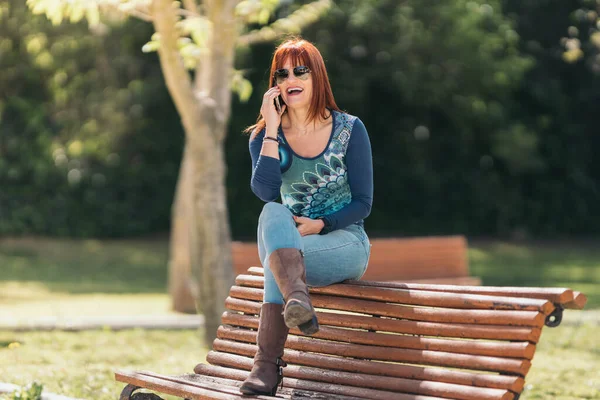 Mulher ruiva falando em seu celular e rindo em voz alta. — Fotografia de Stock