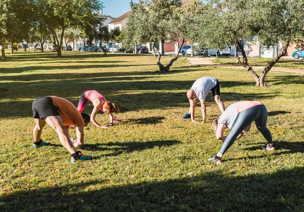 Люди, растягивающие спину во время частной тренировки — стоковое фото