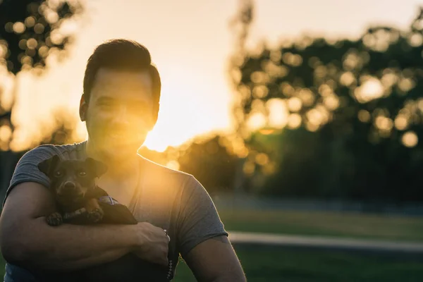 Portrait of young man with his dog in a park — Stock Photo, Image