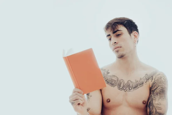 Jovem lendo um livro sem camisa — Fotografia de Stock