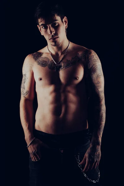 Studio portrait of a young shirtless with tattoos standing — Stock Photo, Image