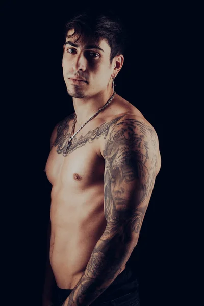 Jovem homem apto com tatuagens nos braços e tronco — Fotografia de Stock