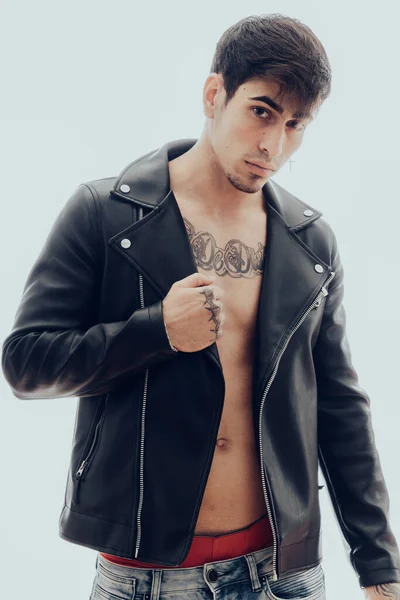 Homem com tatuagens e uma jaqueta de couro preto — Fotografia de Stock