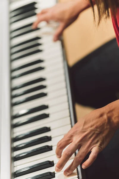 Vertikalt foto av en kvinna som spelar elektroniskt piano — Stockfoto