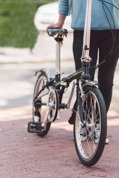 Woman next to a bicycle in the street — Stock Photo, Image