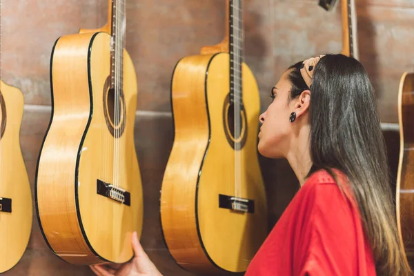 Жінка перевіряє гітари для покупки — стокове фото