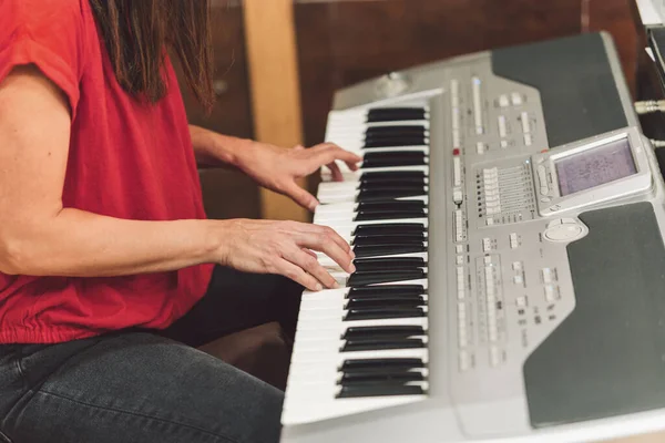 Kvinna som spelar elektroniskt piano — Stockfoto