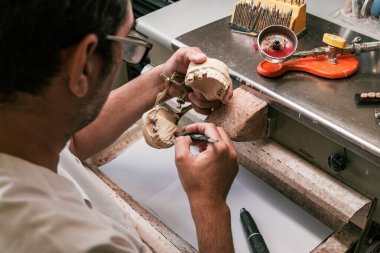 Diş teknisyeni diş protezi eklem makinesini tamir ediyor.