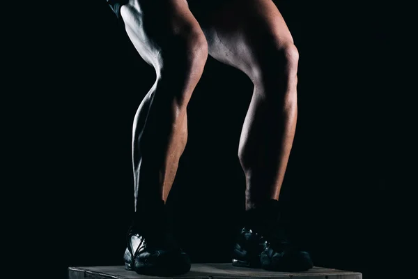 Foto de estúdio da parte inferior de um homem forte pernas com fundo preto — Fotografia de Stock