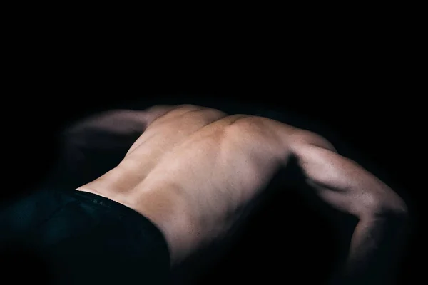 Costas de um homem musculoso fazendo flexões. — Fotografia de Stock