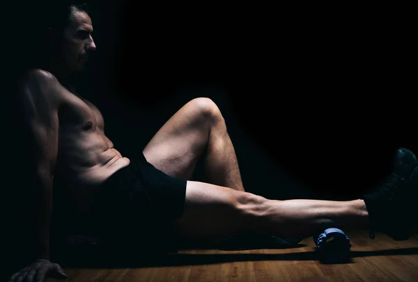 Homem sentado no chão fazendo exercícios de alongamento — Fotografia de Stock