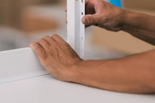 Mani di un uomo che assembla due mobili in un'officina — Foto Stock