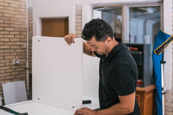 Worker putting together pieces of furniture in a workshop — Stock Photo, Image